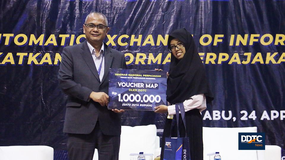 Pemberian doorprize berupa voucher belanja Rp1 juta dan buku PPN terbitan DDTC kepada peserta seminar oleh Managing Partner DDTC. 