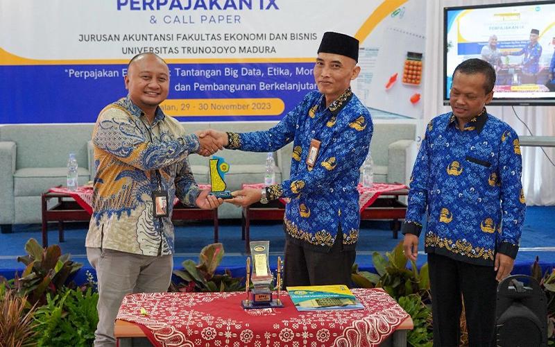 Penyerahan plakat oleh Wakil Dekan FEB UTM Bidang Akademik Yahya Surya Winata kepada Director of Fiscal Research & Advisory DDTC B. Bawono Kristiaji. Kedua pihak melakukan pembaruan MoU tentang pendidikan pajak, Rabu (29/11/2023).