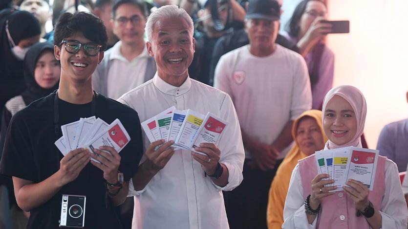 Calon presiden (capres) nomor urut 3 Ganjar Pranowo (tengah) bersama istri Siti Atikoh (kanan) dan anak Alam Ganjar (kiri) menunjukkan surat suara sebelum mencoblos di TPS 11 Lempongsari, Semarang, Jawa Tengah, Rabu (14/2/2024). Pemilu 2024 untuk memilih presiden dan wakil presiden, anggota DPR, DPD, DPRD provinsi dan DPRD kabupaten/kota tersebut dilaksanakan secara serentak di 38 provinsi dengan 204.807.222 pemilih dalam DPT. ANTARA FOTO/Akbar Nugroho Gumay/tom.