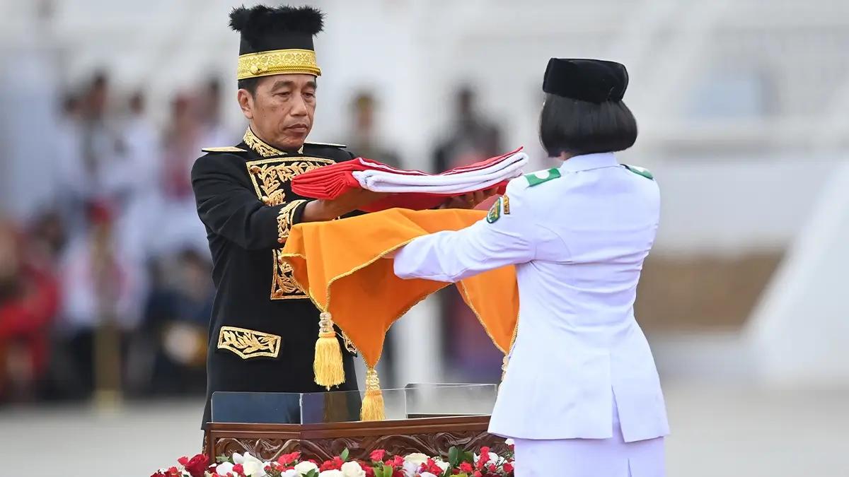 Presiden Joko Widodo (kiri) menyerahkan duplikat Bendera Pusaka kepada anggota Paskibraka 2024 asal Kalimantan Timur Livenia Evelyn Kurniawan (kanan) untuk dikibarkan dalam upacara Peringatan Detik-detik Proklamasi Kemerdekaan Republik Indonesia (RI) di lapangan upacara Istana Negara Ibu Kota Nusantara (IKN), Penajam Paser Utara, Kalimantan Timur, Sabtu (17/8/2024). Upacara dalam rangka hari ulang tahun (HUT) ke-79 RI tersebut mengusung tema Nusantara Baru Indonesia Maju. ANTARA FOTO/Hafidz Mubarak A/app/wpa.